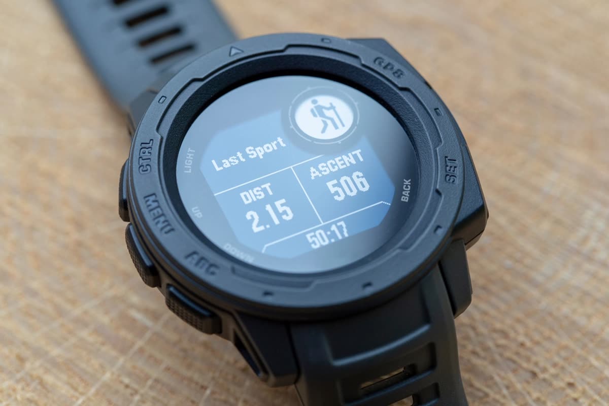 An outdoor GPS watch with a memory-in-pixel display showing distance and ascent