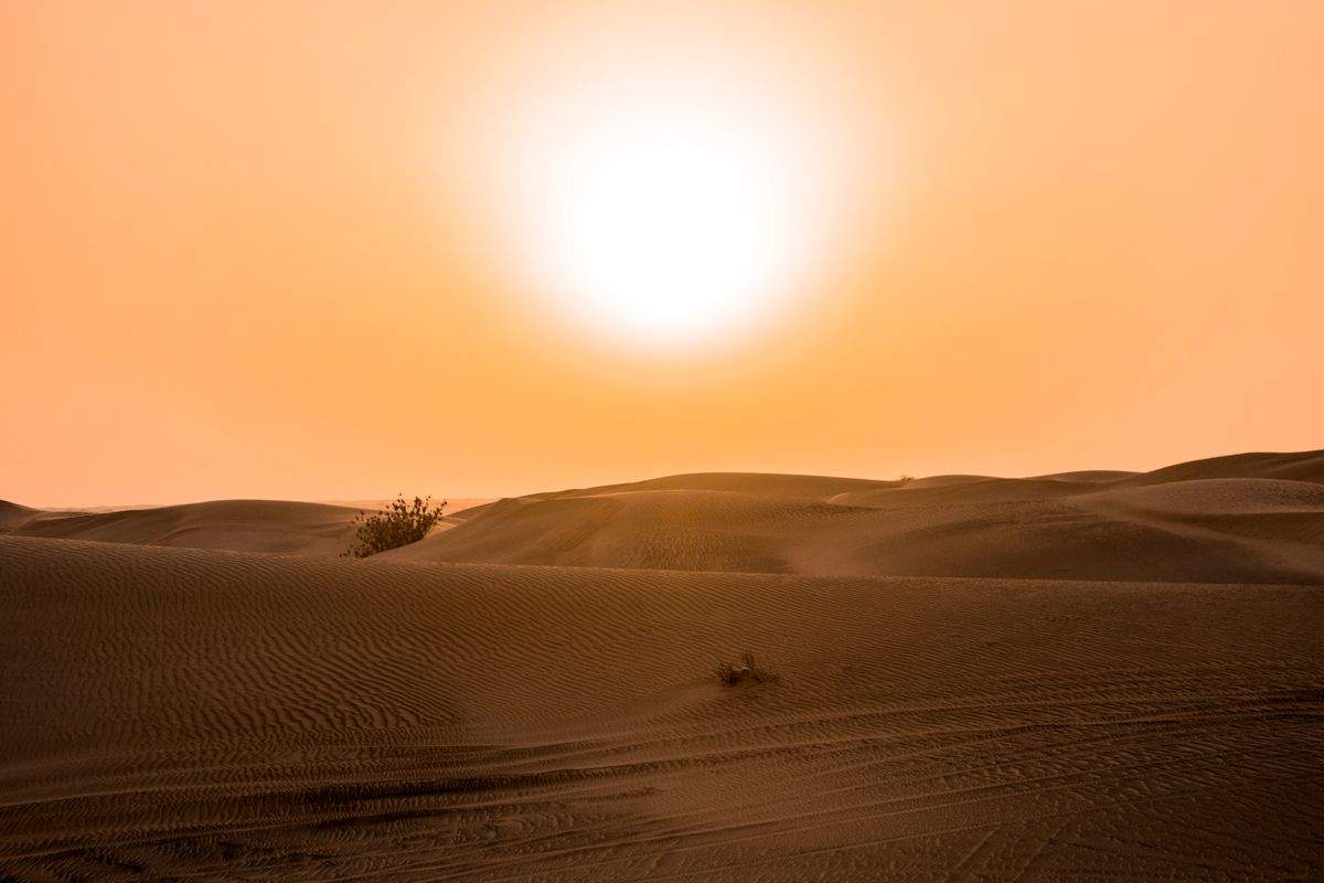 Blazing sun over desert sand dunes during a heatwave